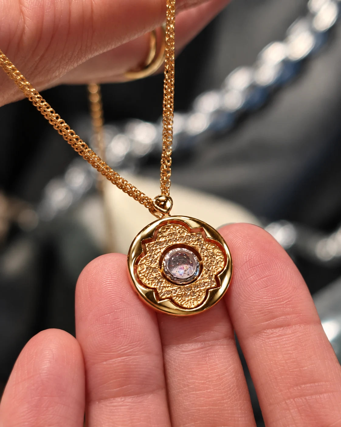 The gold Blessed Sand Necklace held gently between fingers