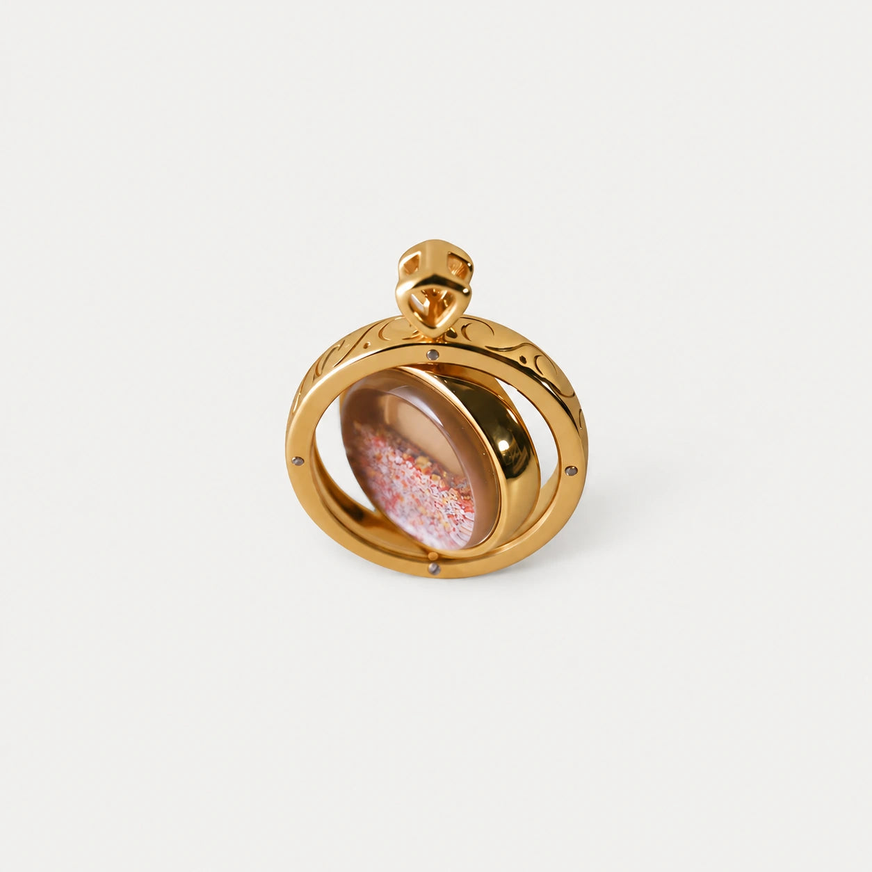 The gold pendant with its rotating centre and mandala sand